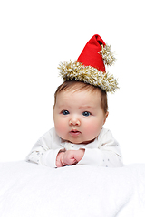 Image showing beautiful baby girl in christmas hat on white blanket