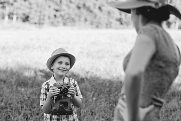 Image showing handsome little boy with retro camera and girl model