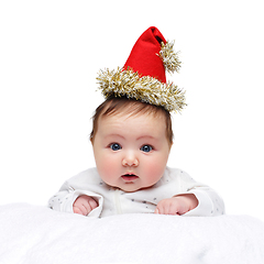 Image showing beautiful baby girl in christmas hat on white blanket