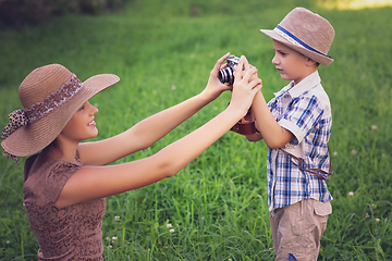 Image showing handsome little boy with retro camera and girl model