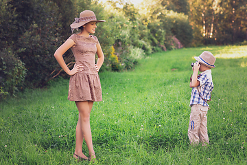 Image showing handsome little boy with retro camera and girl model