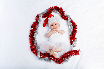 Image showing beautiful baby girl in christmas hat lying