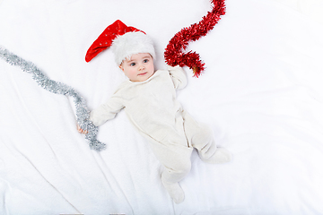 Image showing beautiful baby boy in christmas hat lying