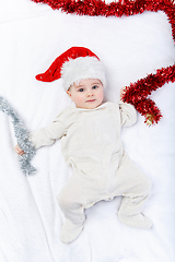 Image showing beautiful baby boy in christmas hat lying