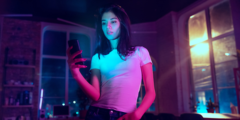 Image showing Cinematic portrait of handsome young woman in neon lighted interior