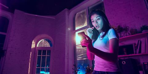 Image showing Cinematic portrait of handsome young woman in neon lighted interior