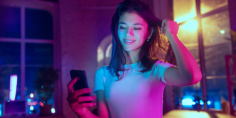 Image showing Cinematic portrait of handsome young woman in neon lighted interior