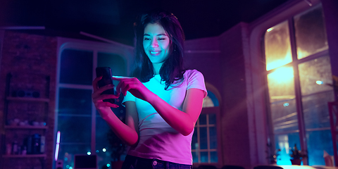 Image showing Cinematic portrait of handsome young woman in neon lighted interior