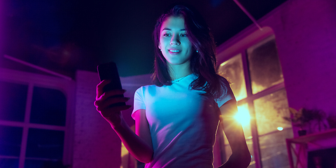 Image showing Cinematic portrait of handsome young woman in neon lighted interior