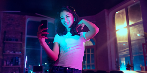 Image showing Cinematic portrait of handsome young woman in neon lighted interior