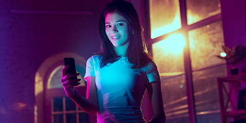 Image showing Cinematic portrait of handsome young woman in neon lighted interior