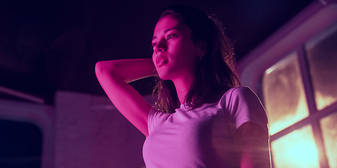 Image showing Cinematic portrait of handsome young woman in neon lighted interior