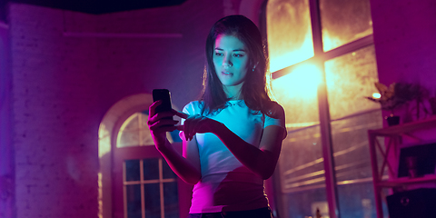 Image showing Cinematic portrait of handsome young woman in neon lighted interior