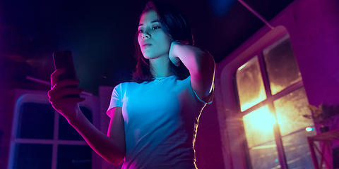 Image showing Cinematic portrait of handsome young woman in neon lighted interior