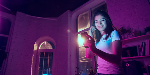 Image showing Cinematic portrait of handsome young woman in neon lighted interior