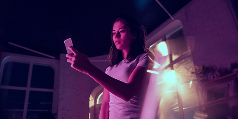 Image showing Cinematic portrait of handsome young woman in neon lighted interior