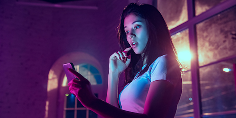 Image showing Cinematic portrait of handsome young woman in neon lighted interior