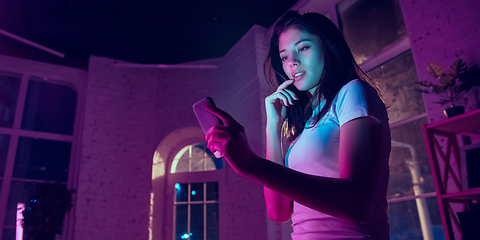 Image showing Cinematic portrait of handsome young woman in neon lighted interior