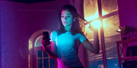 Image showing Cinematic portrait of handsome young woman in neon lighted interior