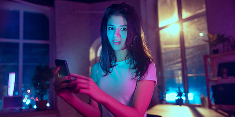 Image showing Cinematic portrait of handsome young woman in neon lighted interior