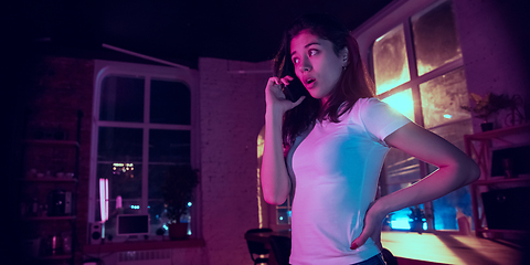 Image showing Cinematic portrait of handsome young woman in neon lighted interior