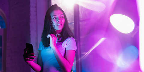 Image showing Cinematic portrait of handsome young woman in neon lighted interior