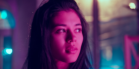 Image showing Cinematic portrait of handsome young woman in neon lighted interior