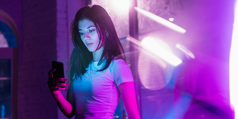 Image showing Cinematic portrait of handsome young woman in neon lighted interior