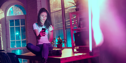 Image showing Cinematic portrait of handsome young woman in neon lighted interior