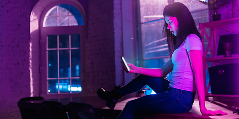 Image showing Cinematic portrait of handsome young woman in neon lighted interior