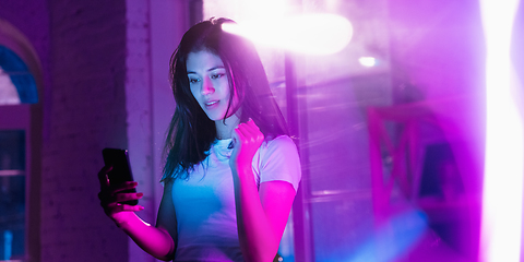 Image showing Cinematic portrait of handsome young woman in neon lighted interior