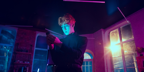 Image showing Cinematic portrait of handsome young man in neon lighted interior