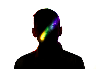 Image showing Dramatic portrait of a man in the dark on white studio background with rainbow colored line