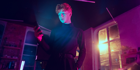 Image showing Cinematic portrait of handsome young man in neon lighted interior