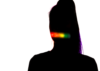 Image showing Dramatic portrait of a girl in the dark on white studio background with rainbow colored line