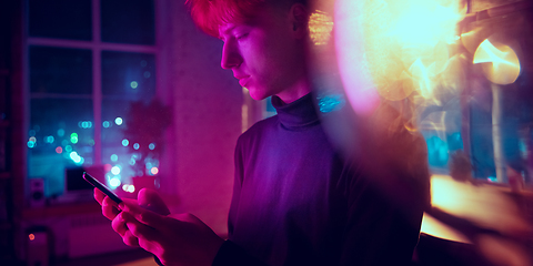 Image showing Cinematic portrait of handsome young man in neon lighted interior