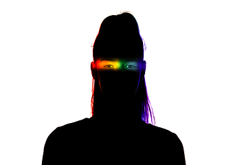 Image showing Dramatic portrait of a girl in the dark on white studio background with rainbow colored line