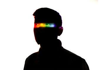 Image showing Dramatic portrait of a man in the dark on white studio background with rainbow colored line