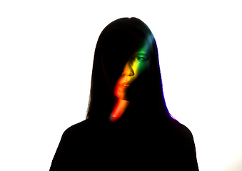 Image showing Dramatic portrait of a girl in the dark on white studio background with rainbow colored line