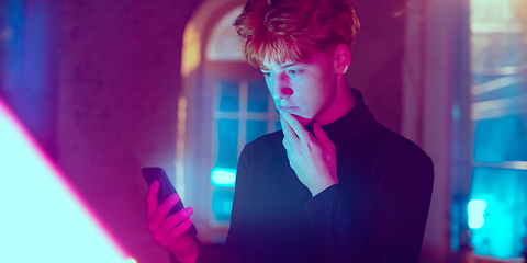 Image showing Cinematic portrait of handsome young man in neon lighted interior