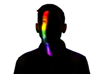 Image showing Dramatic portrait of a man in the dark on white studio background with rainbow colored line