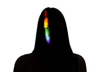 Image showing Dramatic portrait of a girl in the dark on white studio background with rainbow colored line