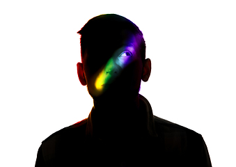 Image showing Dramatic portrait of a man in the dark on white studio background with rainbow colored line