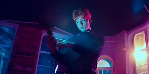 Image showing Cinematic portrait of handsome young man in neon lighted interior