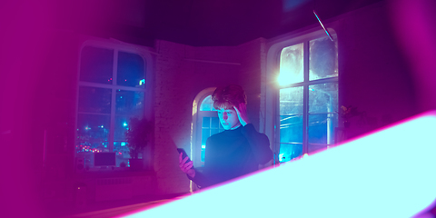 Image showing Cinematic portrait of handsome young man in neon lighted interior