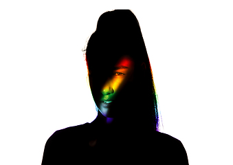 Image showing Dramatic portrait of a girl in the dark on white studio background with rainbow colored line