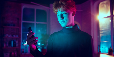 Image showing Cinematic portrait of handsome young man in neon lighted interior
