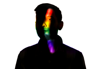 Image showing Dramatic portrait of a man in the dark on white studio background with rainbow colored line