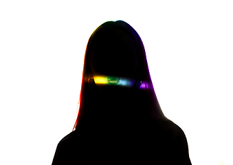 Image showing Dramatic portrait of a girl in the dark on white studio background with rainbow colored line