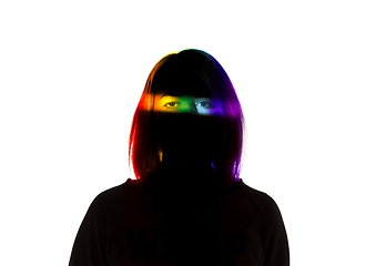 Image showing Dramatic portrait of a girl in the dark on white studio background with rainbow colored line